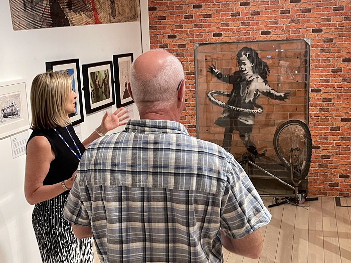 Hula Hooping Girl by Banksy at the National Horseracing Museum in Newmarket, viewed by Tracey Harding and Cllr Ian Shipp